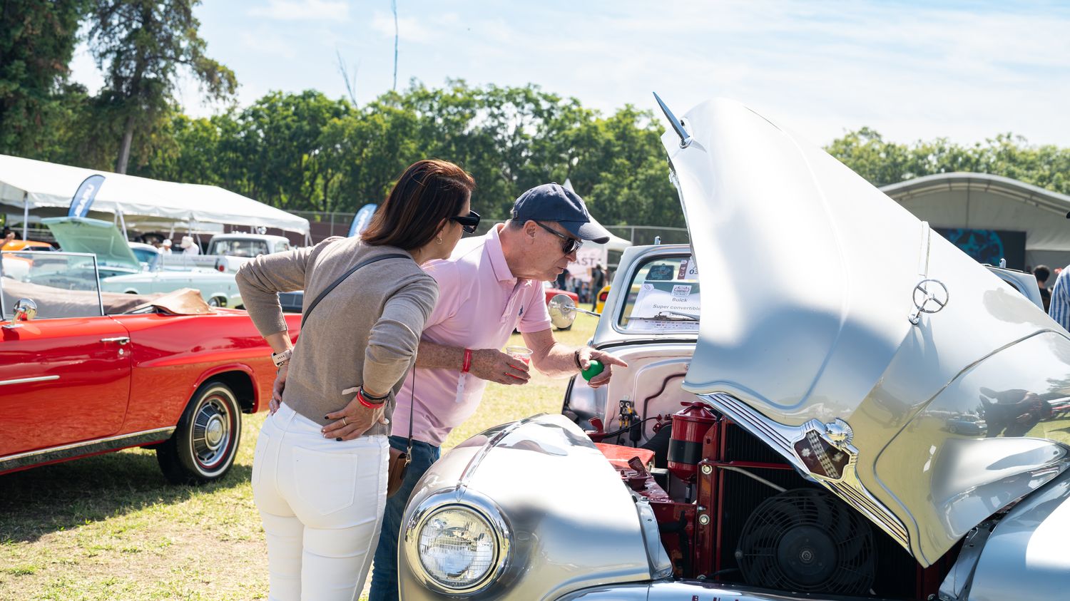 Visitantes observando el motor de un automóvil clásico